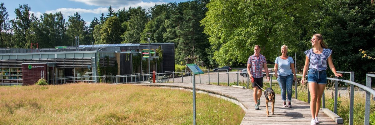 Familie läuft in Richtung eines Sees beim Haus der Nachhaltigkeit